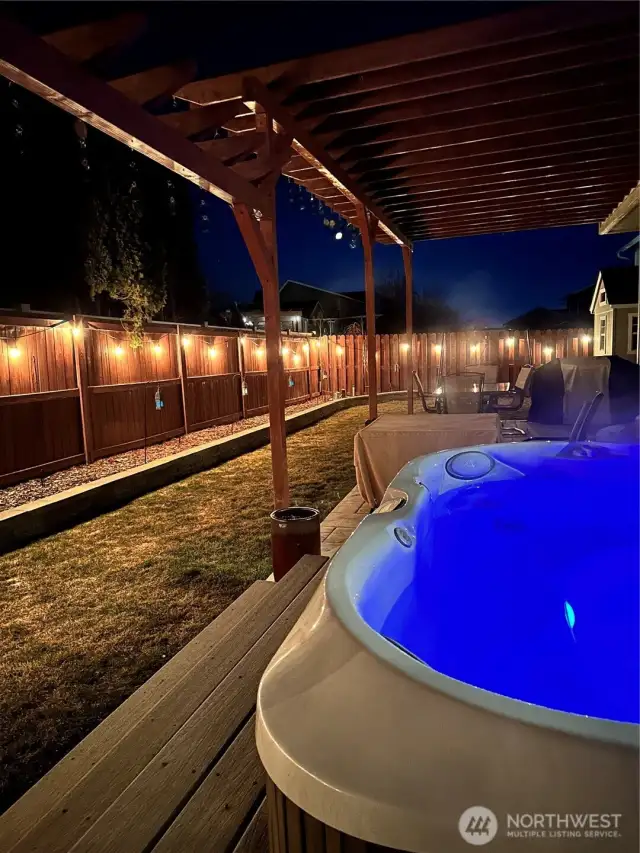 night time with the hot tub in the backyard