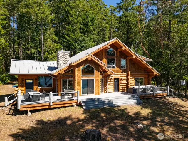 This beautifully crafted log-style home blends seamlessly into its wooded surroundings, offering rustic charm with modern finishes. A spacious deck enhances outdoor living, while large windows capture abundant natural light and water views.