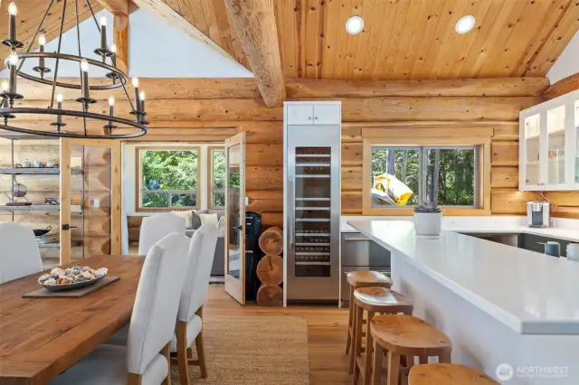 A full-height wine fridge, crisp white quartz counters, and breathtaking ocean outlooks enhance the kitchen’s functionality and luxury, while French doors open to a coastal lounge for effortless flow.
