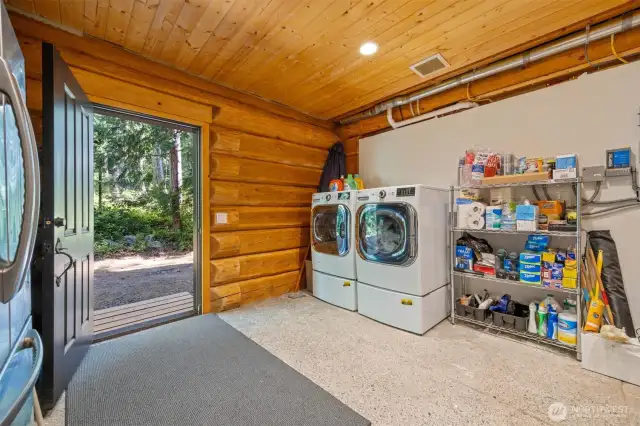 With direct access to the outdoors, the laundry/mudroom offers durable finishes and practical organization. Full-size washer and dryer, utility sink, and shelving make it ideal for daily living or island gear cleanup.