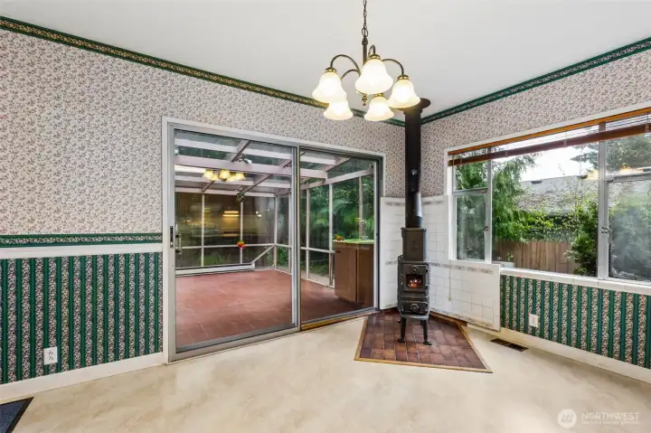 Kitchen eating area with wood stove. Slider to sun room.