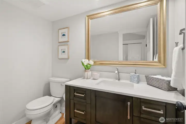 Main floor powder room with quartz counters and rich wood cabinetry. Main floor powder room with quartz counters and rich wood cabinetry.