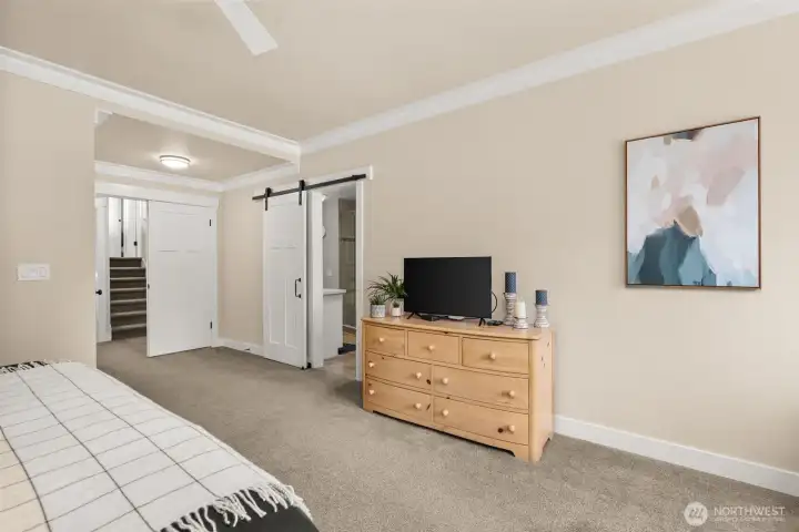 Primary suite featuring barn door detail and easy flow to the upper level bedrooms. Primary suite featuring barn door detail and easy flow to the upper level bedrooms.