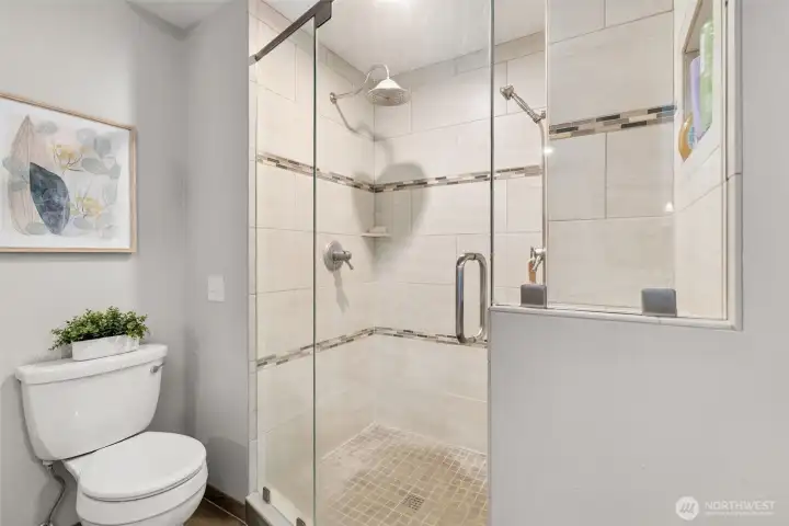 Elegant primary bathroom with quartz counters, custom cabinetry, and tile shower. Elegant primary bathroom with quartz counters, custom cabinetry, and tile shower.