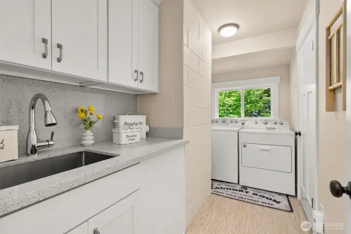 Functional laundry room with utility sink, extra cabinetry, and additional storage space. Functional laundry room with utility sink, extra cabinetry, and additional storage space.