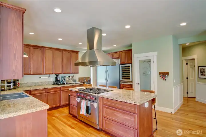 Chefs dream kitchen with 6 burner gas Wolf range, double sized built-in refrigerator/freezer, wine cooler, granite countertops, hardwood floors and an abundance of beautiful cabinetry. Kitchen faces the incredible back patio and yard area.