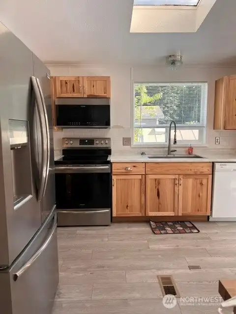 Kitchen with new refrigerator, stove & microwave
