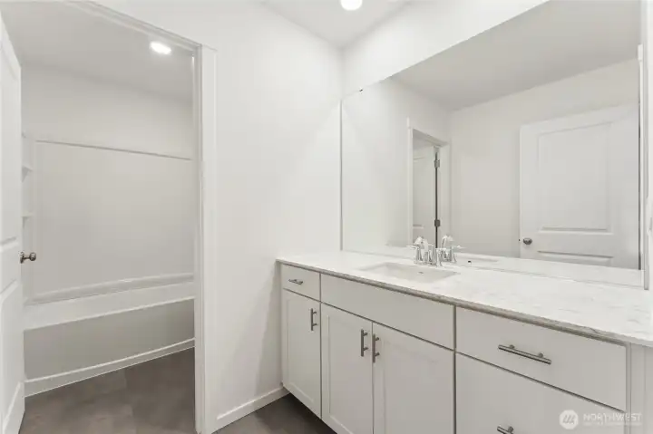 Secondary bedroom with privacy door to shower. Quartz countertops, soft close cabinets, & cabinet pulls. Virtually Staged. Secondary bedroom with privacy door to shower. Quartz countertops, soft close cabinets, & cabinet pulls. Virtually Staged.