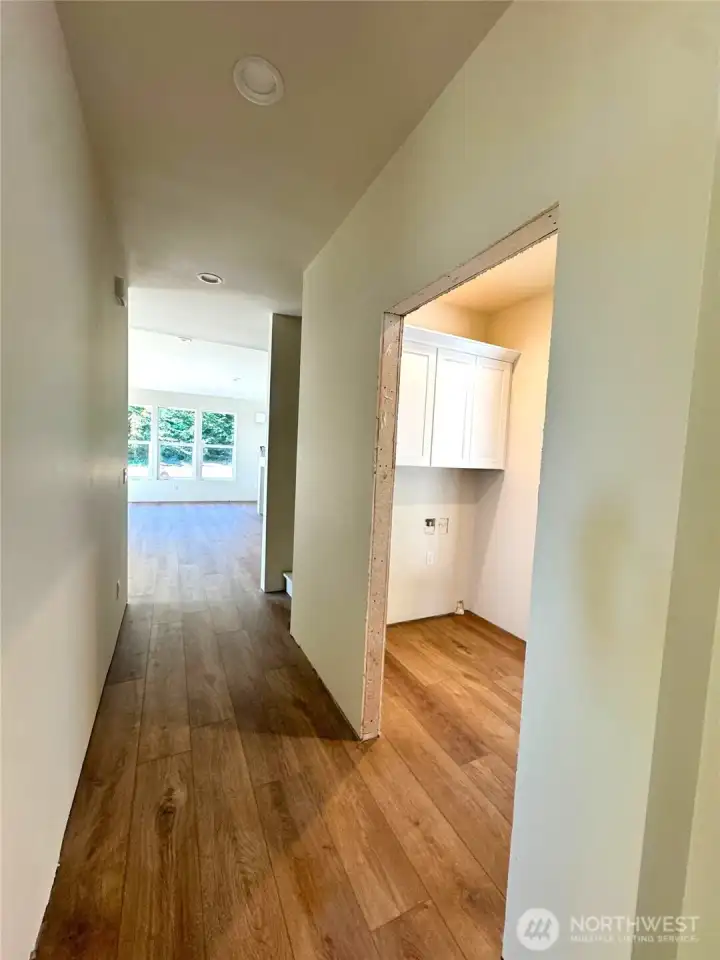 Looking down hall from entry, utility room & garage access to right - great room ahead Looking down hall from entry, utility room & garage access to right - great room ahead
