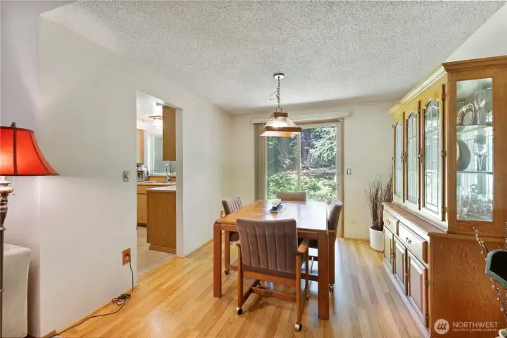 Dining room with LVP flooring, leads into kitchen and backyard. Ample space for China cabinet and table for up to 6 comfortably