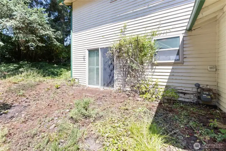Side yard of house. Sliding door leads to great room and window is for the full bath on lower level