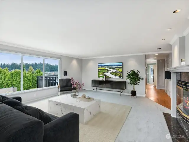 Large family room with gas fireplace and amazing view of Cascade Mountain range.  (virtually staged)