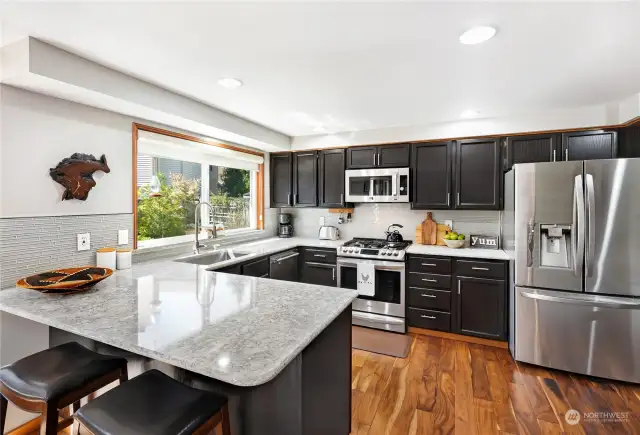 Step into the chef's kitchen, featuring quartz countertops, a full backsplash, and a gas convection oven—ideal for culinary enthusiasts.