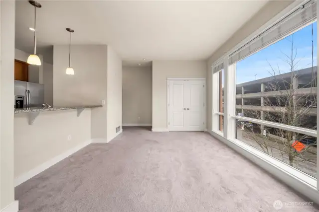 Spacious living room with floor-to-ceiling windows and open concept bar counter to kitchen.