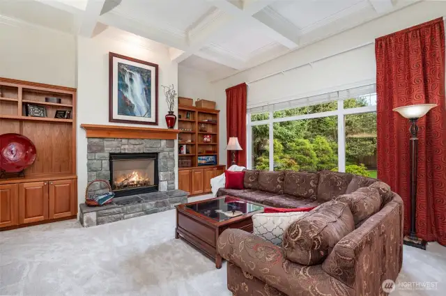 Built-in book cases, gas fireplace, coffered ceiling and large windows to the serene backyard.
