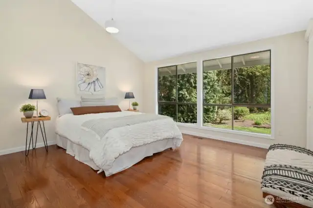Primary bedroom looks out over peaceful backyard