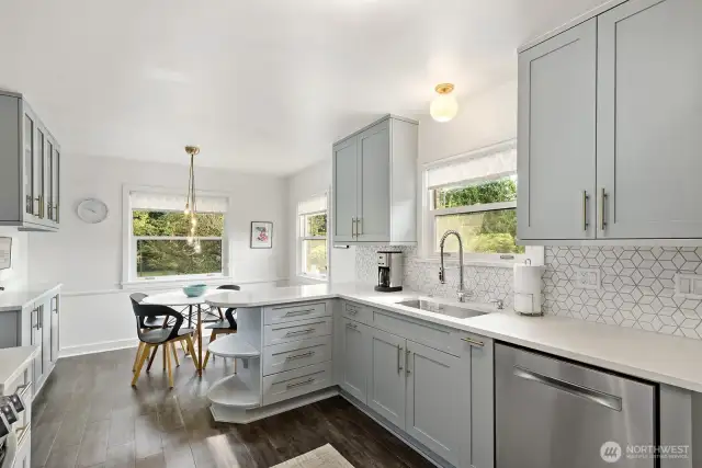 Updated kitchen boasts quartz countertops, undermount sink, stainless steel appliances, with a little rounded corner nod to the Mid Century era.
