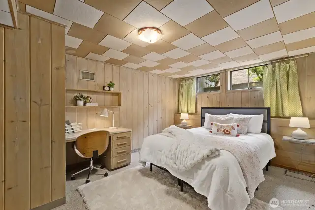 Non conforming carpeted bedroom with wide plank beautiful blonde wood paneling.