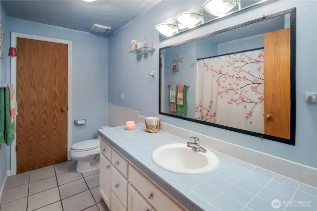 Full hall bath has tile floors and tile counters.