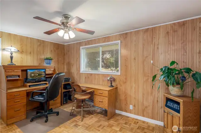 Den has parquet flooring and is right off the entry for a convenient home office.