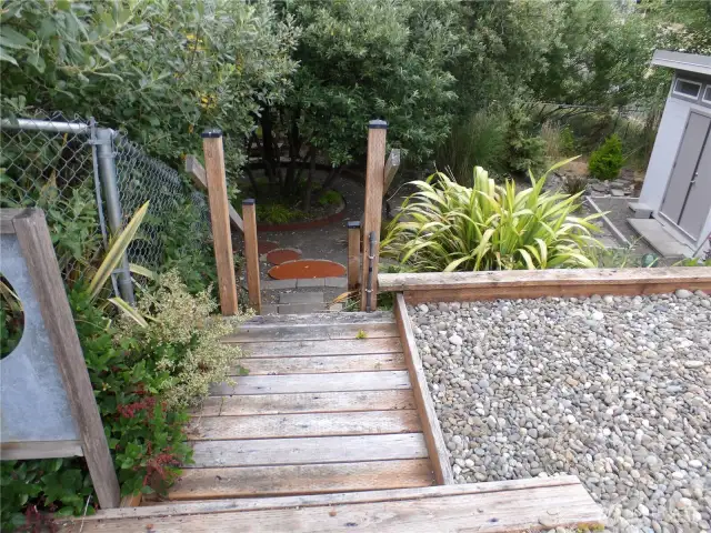 Stairs at east end of property  to the lower level to the fire pit and wimsical surroundings to enjoy.