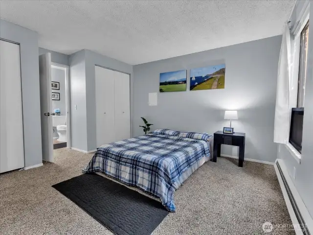 Renewed primary bedroom with new carpet and paint, connected to bathroom.