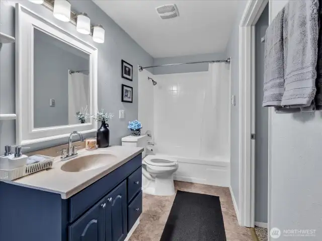 Bright bathroom featuring modern lighting, updated plumbing, and refinished tub and tile.