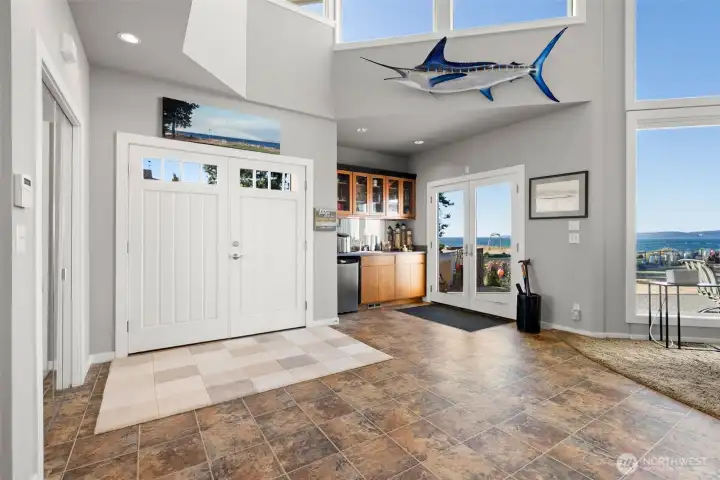 Stepless entry gets you in through double doors.  A wet bar, convenient to patio access through French doors,  has a sink, beverage refrigerator and cabinetry for your needs.  (Sail fish does not convey)