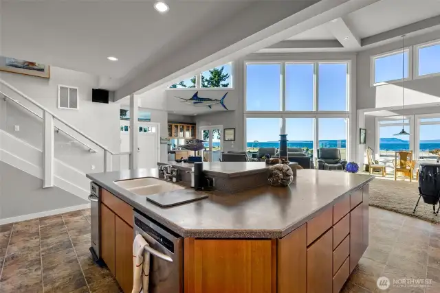 Nicely outfitted kitchen island with stainless steel trash compactor and dishwasher with enamel sink- all within cherry cabinetry topped with solid surface countertops