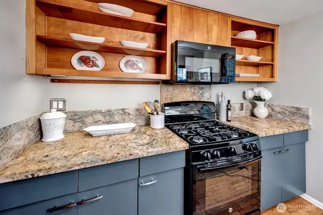 ~gas range, open cabinets above, there is also a pantry closet
