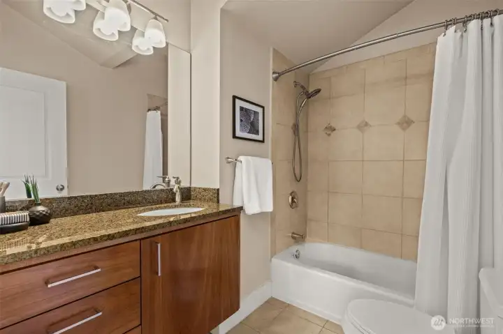 En suite bathroom with wall tiling and tub insert