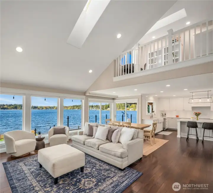 Vaulted ceilings and dramatic walls of glass frame panoramic water views, filling the home with light and serenity.