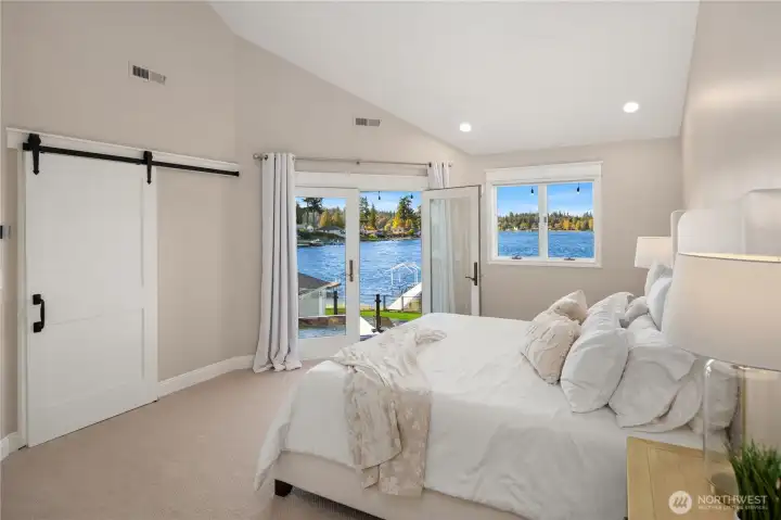 Main-level Primary opens to the hot tub offering crystal blue waters.
