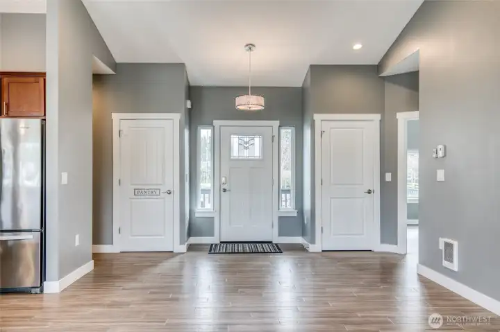 view of front entrance, pantry and closet