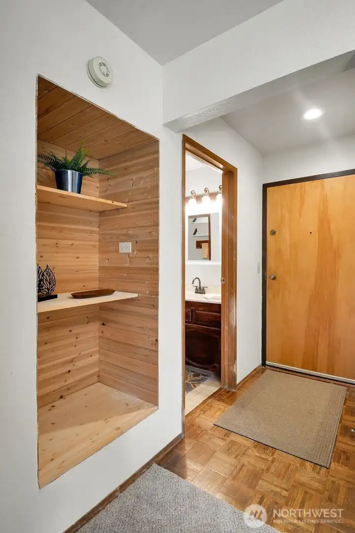 Open built-in shelving just off the entrance has intentional design and function in mind. Open built-in shelving just off the entrance has intentional design and function in mind.