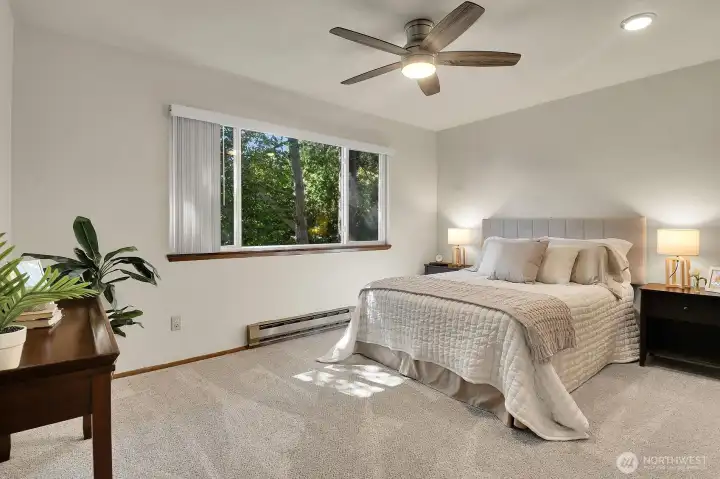 Main bedroom offers a large picture window and ceiling fan to circulate the air. Main bedroom offers a large picture window and ceiling fan to circulate the air.