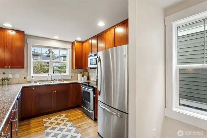 The spacious kitchen is a standout, offering shaker-style cherrywood cabinetry, slab granite counters and stainless steel appliances.