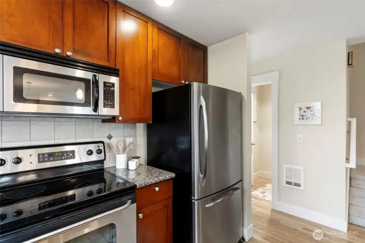 Cherry wood cabinets, granite counters, tiled backsplash, stainless appliances and a refinished oak floor makes this chefs kitchen a dream to work in.