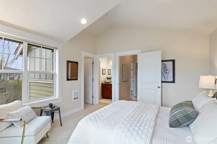 The primary features a large room with vaulted ceilings, room for extra furniture, a walk-in closet and an en-suite full bathroom.