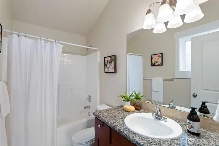 A full bathroom with a granite counter for the second upper floor  bedroom.