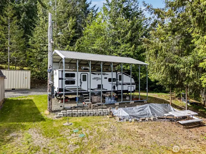 Rear view of RV setup and outdoor space under carport