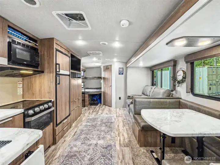 Bright interior view highlighting open living, dining, and kitchen layout