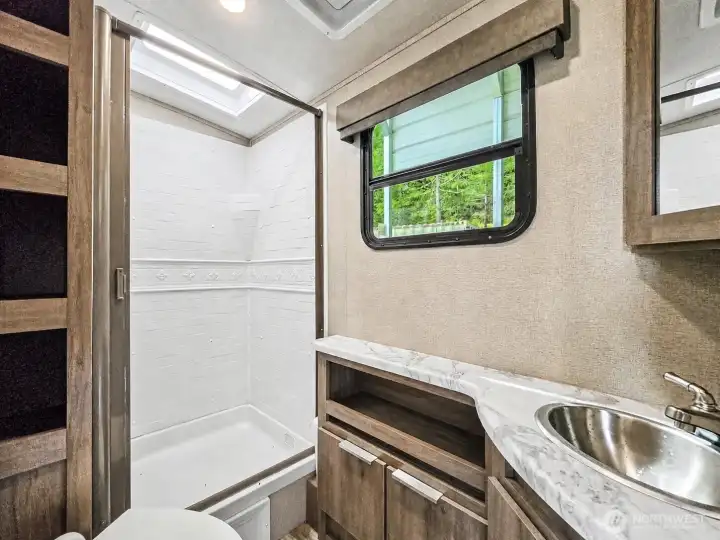 Bathroom with walk-in shower, vanity, and storage