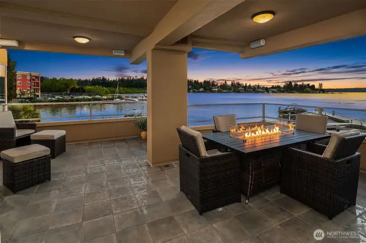 al fresco dining and casual lounge seating frame an unobstructed panorama of Yarrow Bay from this spacious covered outdoor living room.
