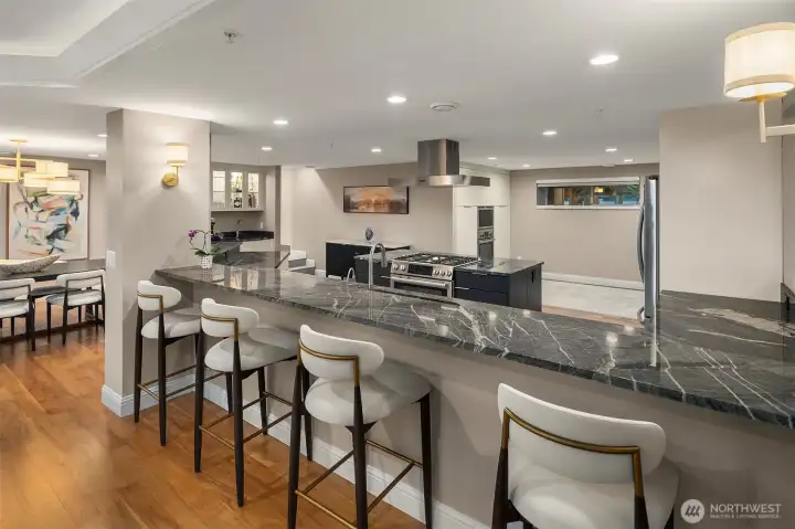 Dark, veined marble stretches the full length of the bar, setting a dramatic tone for a kitchen that means business