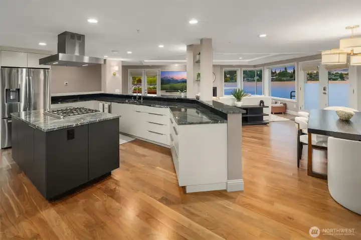 Generous, gorgeous, and genuinely functional —  sweeping dark marble surfaces, crisp contrasting gray and white cabinetry, and a layout that flows effortlessly into the dining area and living room beyond. Cook with the lake as your backdrop, entertain without missing a moment.