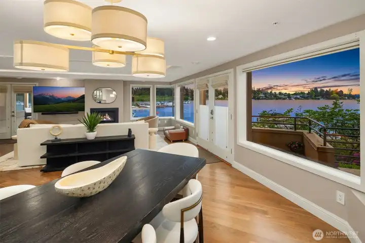 Sunset over Lake Washington becomes the evening's centerpiece — visible from the dining table, from the living room beyond, from every corner of this extraordinary space. With the deck just steps away and the fireplace glowing within, the line between inside and outside simply disappears.