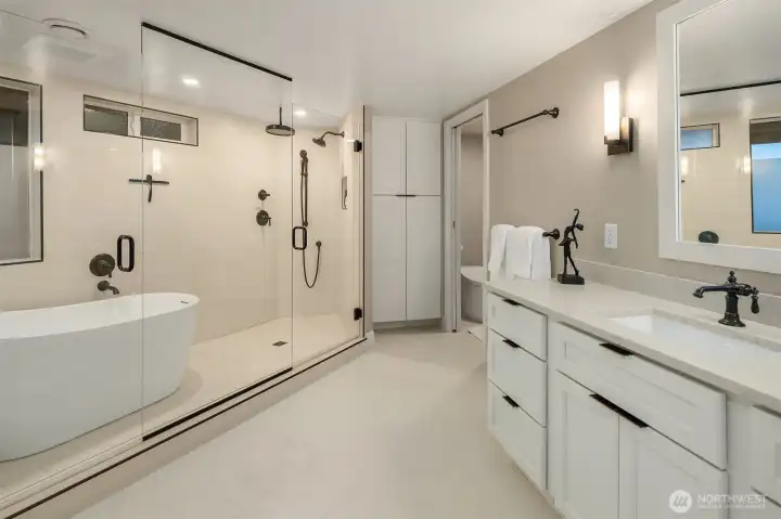 The primary bath is a study in quiet luxury that rivals the finest spa retreats — dual vanities offer effortless space for two, while the generous walk-in shower with multiple shower heads transforms the morning routine into something worth savoring. Crisp, calm, and impeccably finished.