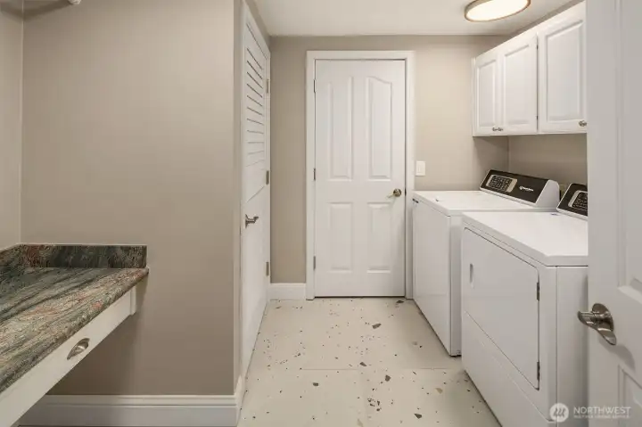 Not all heroes wear capes — the laundry room earns its keep with commercial-grade Speed Queen appliances built to outlast the rest, generous cabinet storage behind every door, and a folding table that makes the chore almost enjoyable. Function elevated to an art form, right down to the last detail.