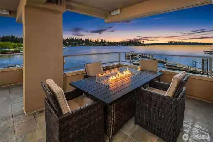End every day like this — gathered around the fire table on the covered view deck as the last light fades over Yarrow Bay. Sheltered, warm, and entirely unhurried. Some homes have a view. This one has a life.